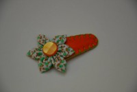 Gancho laranja em feltro com flor.